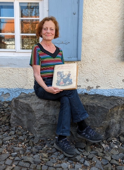 Museumsleiterin Beate Bickel zeigt die Abbildung zum Märchen „Der Wolf und die sieben jungen Geißlein“.
