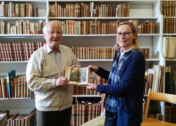 Die Arolsen Bibliothekarin Susann Enß übergibt ihren „Niederländischen Staden“ an den Geschäftsführer des Museums Wolfgang Schiffner. Der Band kann ab sofort im Museum betrachtet werden.